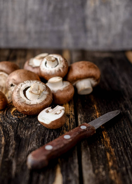 Brown mushrooms on old dark wooden background - Fotoğraf, Görsel