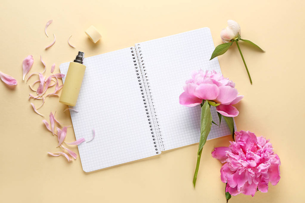 Beautiful fresh peony flowers and open notebook on color background - Photo, image