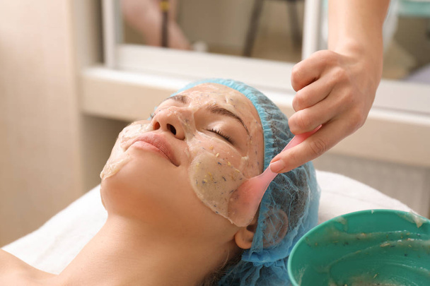 Piękna kobieta w trakcie leczenia maską twarzy w salonie piękności - Zdjęcie, obraz