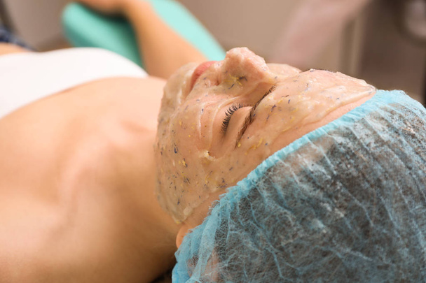 Hermosa mujer en tratamiento con mascarilla facial en salón de belleza
 - Foto, Imagen