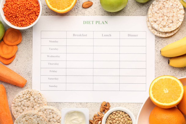 Diferentes alimentos saludables con plan de dieta en mesa gris
 - Foto, imagen