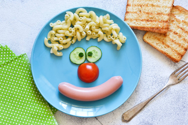 Lunch for children. Funny clown on a blue plate. View from above - Foto, Imagem