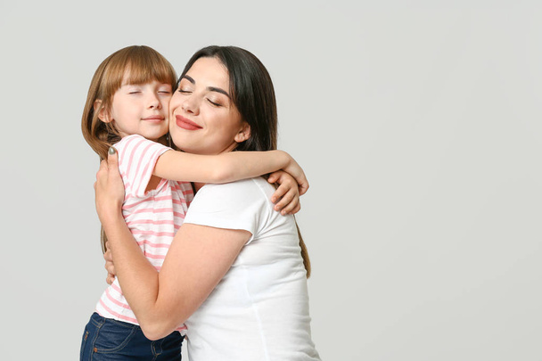Portrait of happy mother and daughter on light background - Foto, immagini