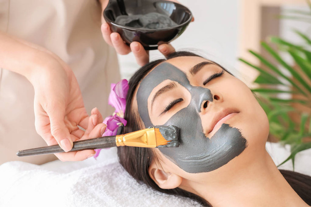 Красива Азіатська жінка проходить лікування за допомогою маски для обличчя в салоні краси - Фото, зображення