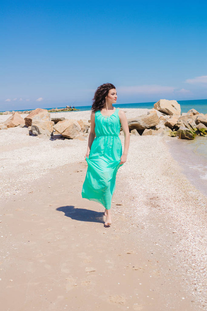 Молода красива дівчина в довгій сукні на пляжі
  - Фото, зображення
