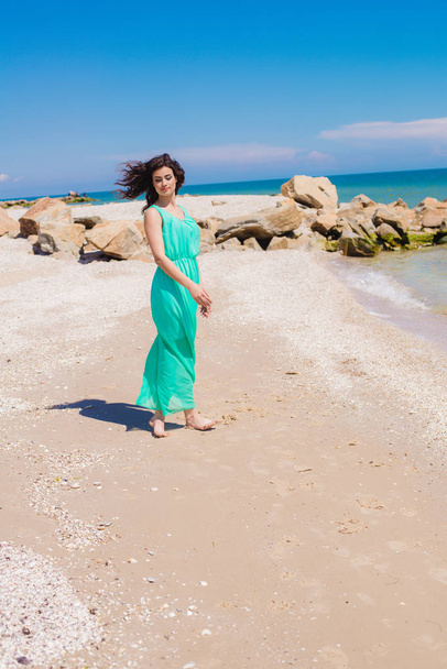 Молода красива дівчина в довгій сукні на пляжі
  - Фото, зображення