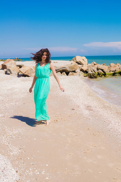 Young beautiful girl in a long dress on the beach  - Фото, зображення