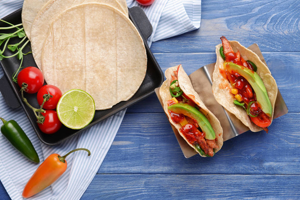Smakelijke verse taco's op kleur houten achtergrond - Foto, afbeelding