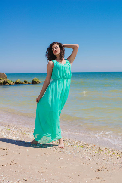 Young beautiful girl in a long dress on the beach  - Zdjęcie, obraz