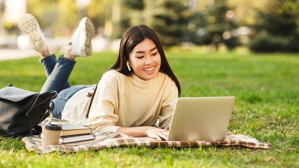 glückliches Studentenmädchen mit Laptop bereitet sich auf Prüfungen im Freien vor - Foto, Bild