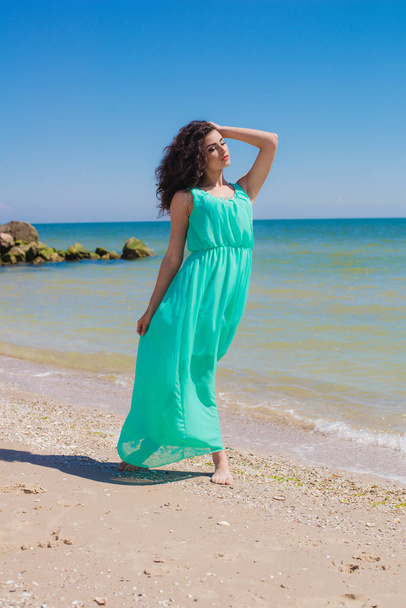 Young beautiful girl in a long dress on the beach  - Фото, зображення