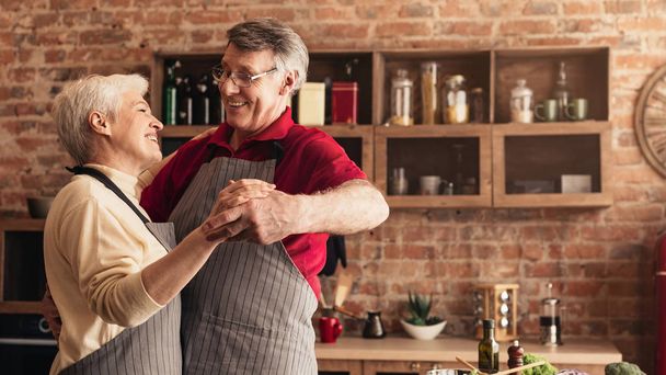 Loving senior couple dancing at kitchen, free space - Foto, Bild
