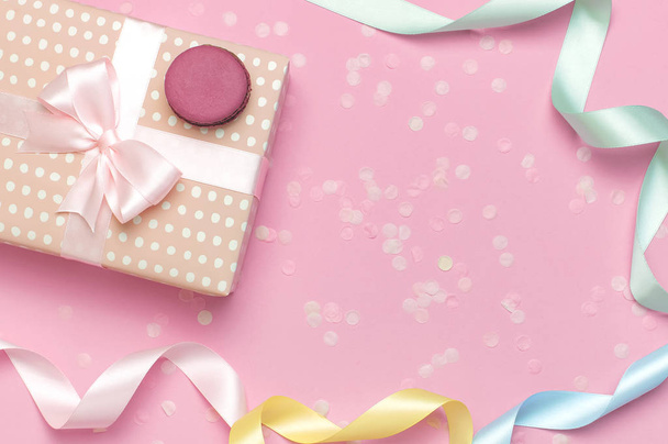 ピンクの背景の上のビューにギフトやプレゼントボックス美しいお祝いのリボンケーキマカロンやマカロン紙吹雪。お祝いの休日の誕生日、バレンタインデー、3月8日、母の日のためのフラットレイ構成 - 写真・画像