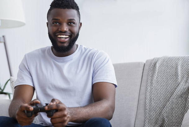 Νεαρός που παίζει βιντεοπαιχνίδια στο σπίτι - Φωτογραφία, εικόνα
