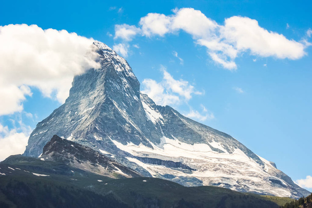 Amazing view of Matterhorn mountain, Switzerland photographed from Zermatt in summer season. Swiss Alps. Alpine landscape. Beautiful mountains. Sunny day, blue sky with clouds - Photo, Image