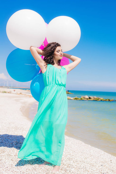 Beautiful girl on the beach with colorful balloons  - Foto, afbeelding