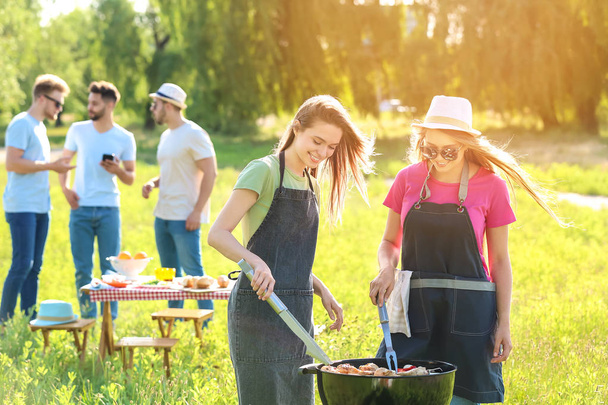 Friends cooking tasty food on barbecue grill outdoors - Fotoğraf, Görsel