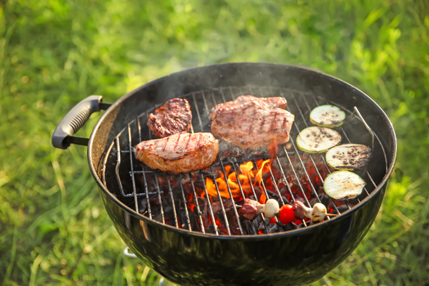 Cooking of tasty food on barbecue grill outdoors - 写真・画像