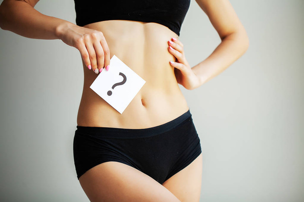 Zdrowia. Ciało kobiety w bieliźnie z pytanie karty w pobliżu brzucha - Zdjęcie, obraz