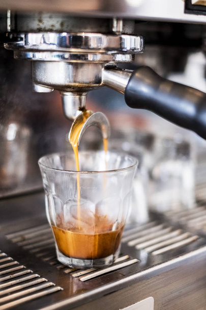 Kahve dükkanında cam kahve döken ticari espresso makinesi yakın çekim. - Fotoğraf, Görsel