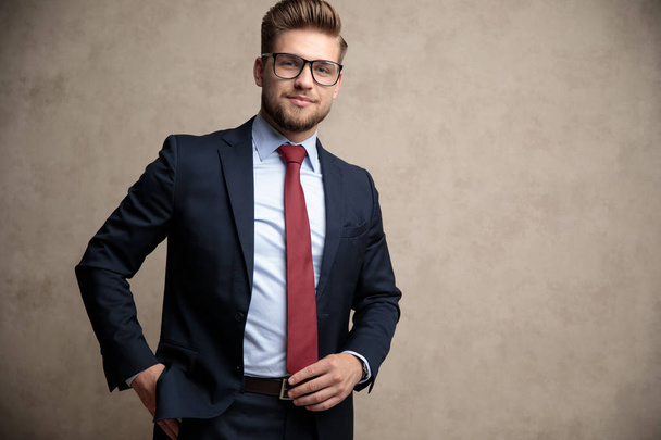 positiver Geschäftsmann, der seine Krawatte und sein Standing anpasst - Foto, Bild
