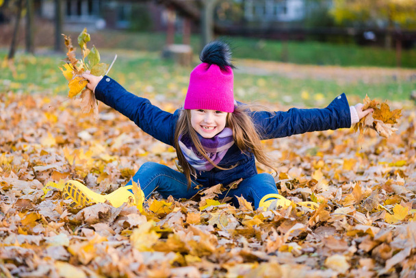 Adorable girl having fun on autumn day - Photo, Image
