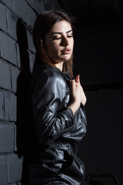 Girl in a leather suit in a dark room - Foto, immagini