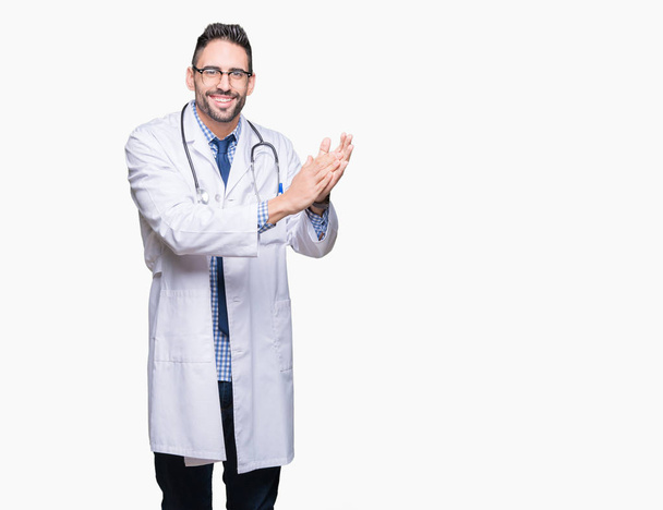 Handsome young doctor man over isolated background Clapping and applauding happy and joyful, smiling proud hands together - Photo, Image