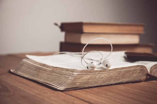 Vintage tone of a Bible with headphones. Hearing the voice of God concept. - Foto, Imagen