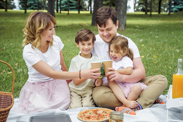 Happy family with kids resting on the grass during a picnic. Happiness and harmony in family life. - Foto, immagini
