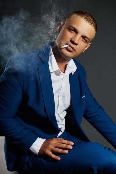 Contrast portrait of a Smoking man businessman in an expensive b - Photo, Image