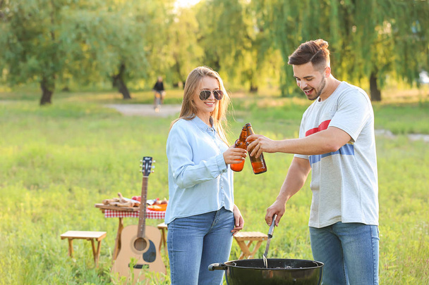 Young couple drinking beer at barbecue party outdoors - Photo, image