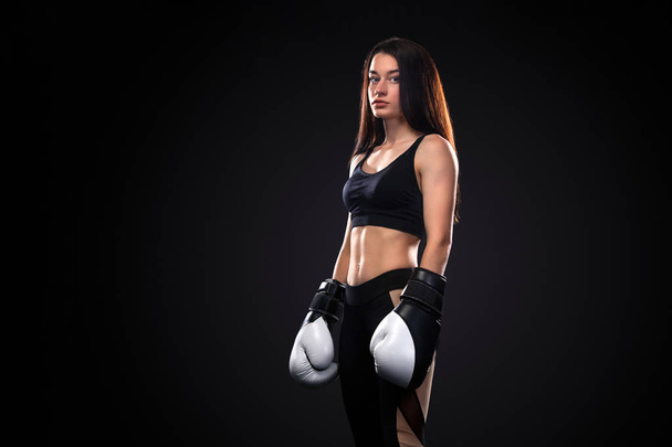 Sportsman, woman boxer fighting in gloves on black background. Boxing and fitness concept. - Фото, зображення