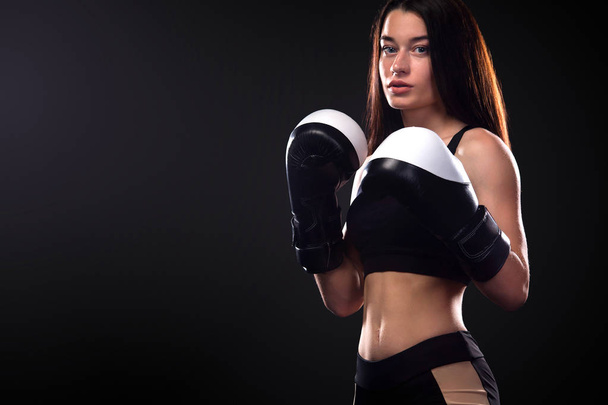 Sportsman, woman boxer fighting in gloves on black background. Boxing and fitness concept. - Fotoğraf, Görsel