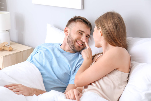 Portrait of happy young couple in bedroom - Foto, imagen