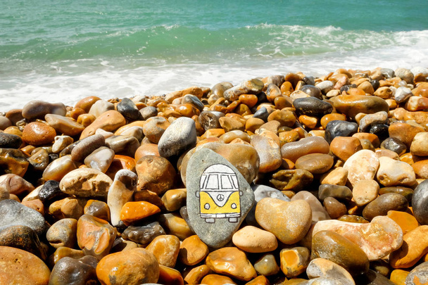 A camper van painted onto a pebble on the beach - Photo, Image