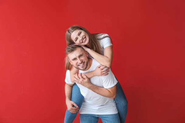Porträt eines glücklichen jungen Paares auf farbigem Hintergrund - Foto, Bild