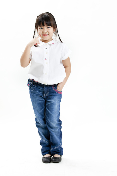 Little girl portrait with white shirt and blue jeans on the white background - Fotografie, Obrázek