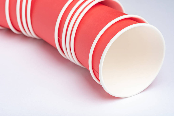Красные экологически чистые бумажные стаканчики для вечеринки на белом фоне
 - Фото, изображение