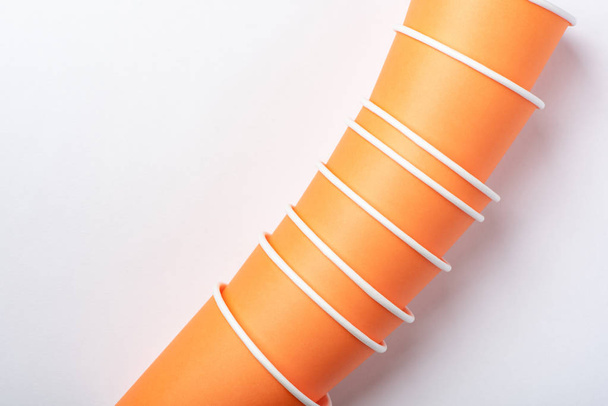 Orange környezetbarát papír csésze egy fél fehér alapon - Fotó, kép