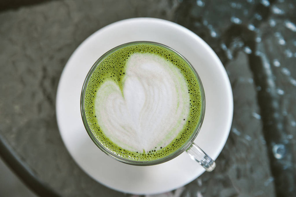 Zielony Matcha latte na tle. Zdrowy napój. - Zdjęcie, obraz