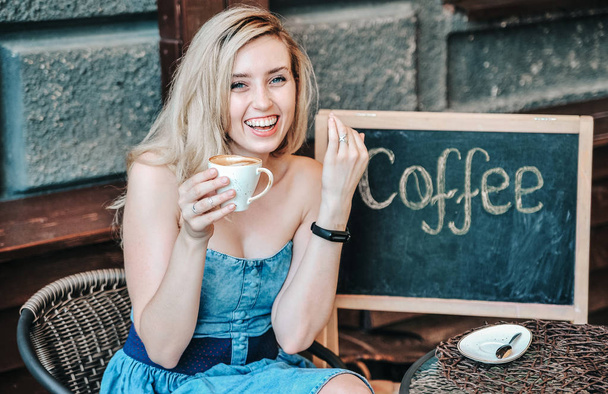 schöne junge Frau trinkt Kaffee im Kaffeehaus. - Foto, Bild