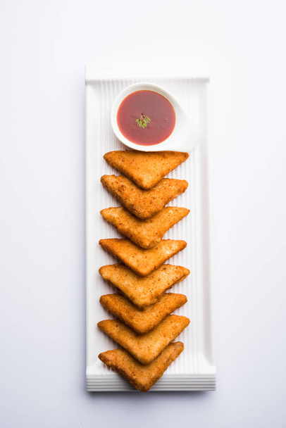 triangles de pommes de terre croustillantes ou batata vada recouvert de chapelure, puis frit. servi avec du ketchup aux tomates. focus sélectif
 - Photo, image