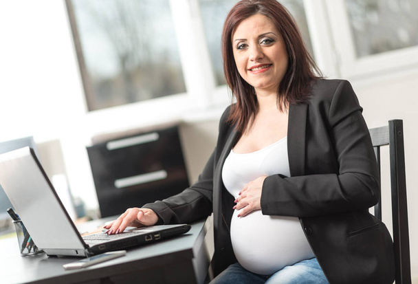 Portret van lachende zwangere zakenvrouw - Foto, afbeelding
