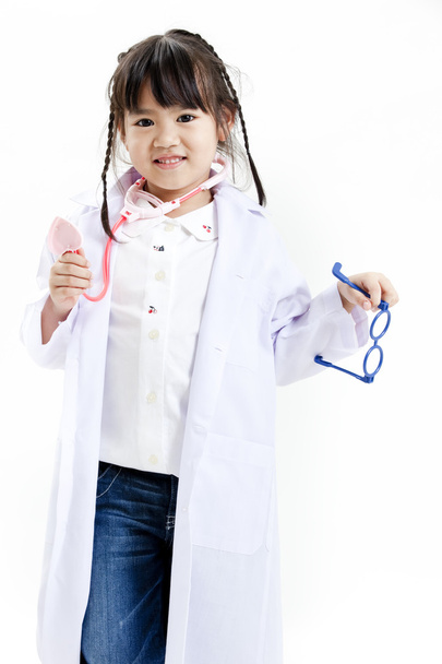 A young asian girl having fun playing dress up as a doctor - Foto, afbeelding