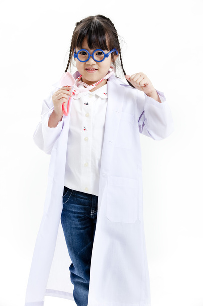 Молода азіатська дівчина весело грає в одягаються як лікар
 - Фото, зображення