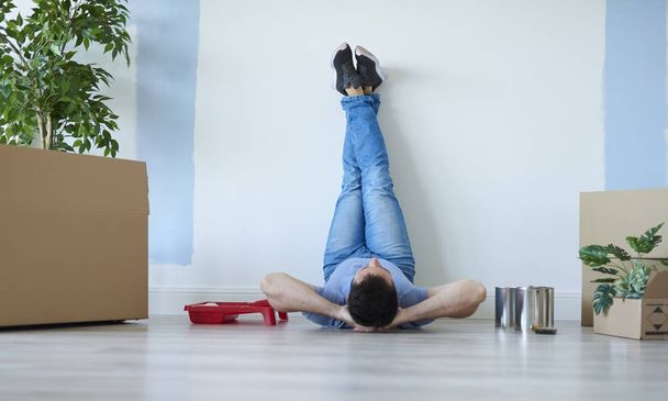 Rear view of man catching a break during moving house  - Foto, Imagem