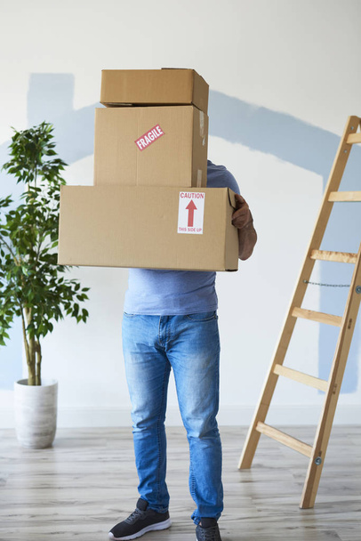 Man holding stack of boxes in front of his face  - Photo, Image
