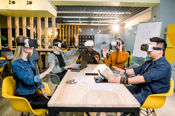 Young happy friends testing video games wearing virtual reality glasses indoors - Cheerful people having fun with new trends technology - Gaming concept - Φωτογραφία, εικόνα