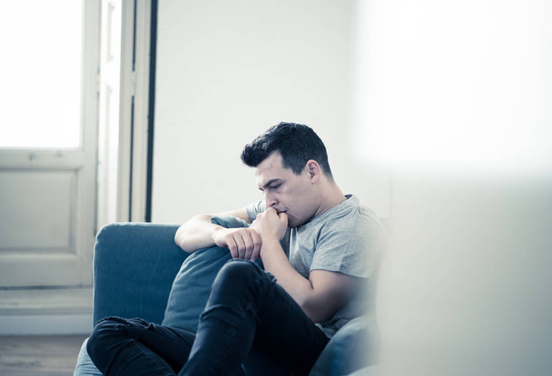 Портрет молодого чоловіка, що б'ється в депресії і відчайдушно плаче на самоті в дивані, страждає від емоційного болю і нещастя. У людей Розбите серце, знущання над депресією та концепція психічного здоров'я
. - Фото, зображення